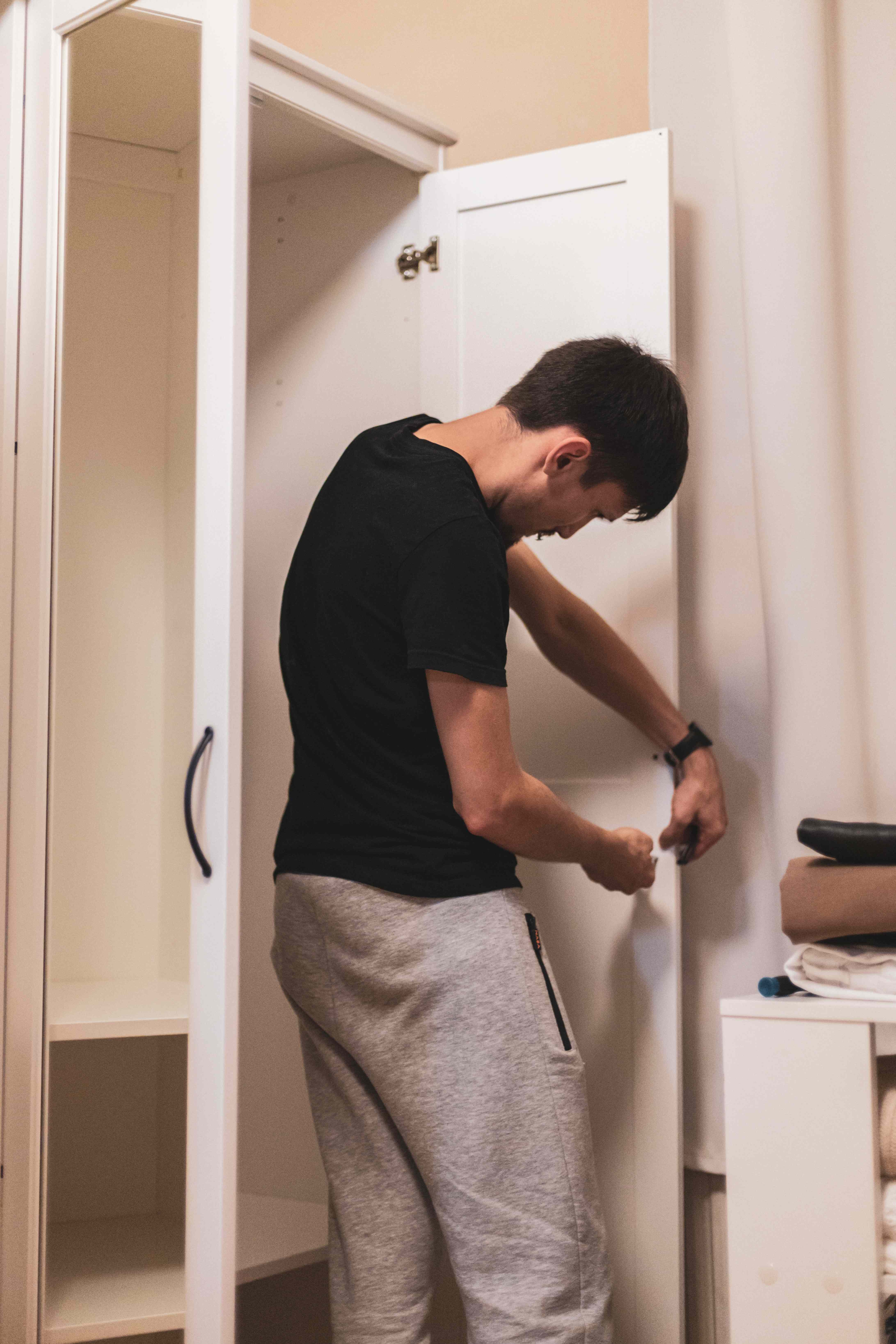 Worker adjusting a closet door hinge