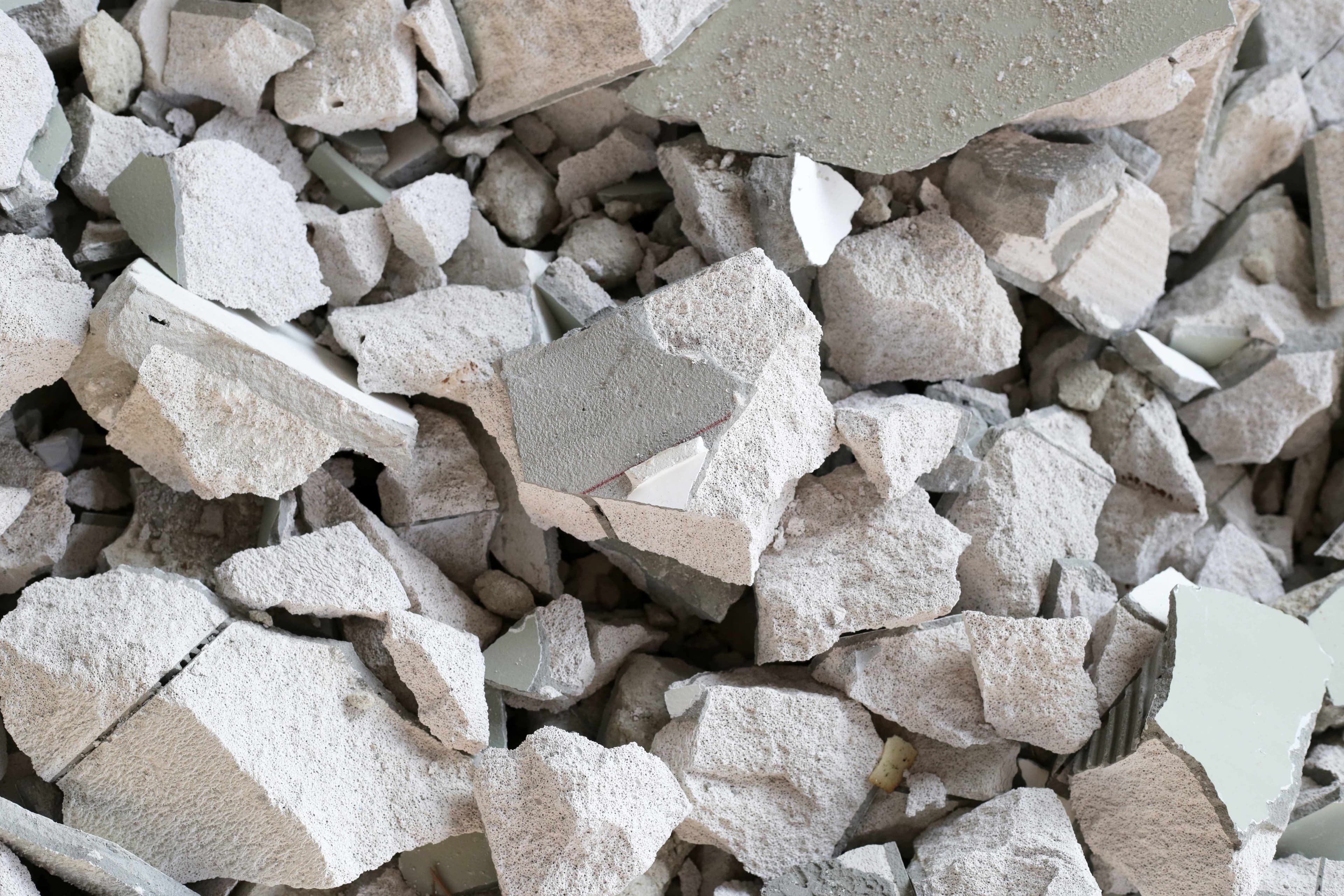 Close-up of a pile of broken drywall, tile, and construction debris fragments