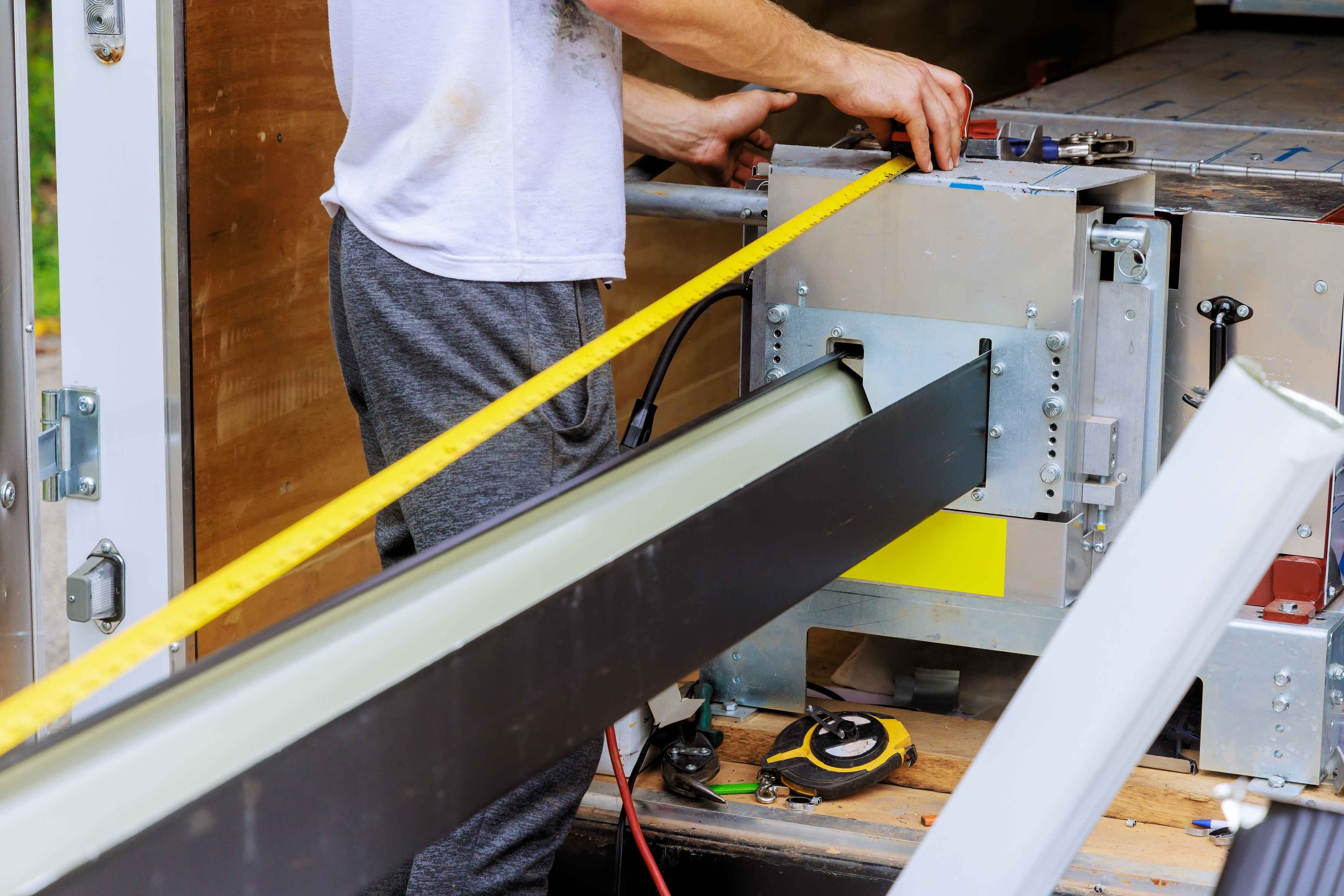 Gutter material being measured and marked before being cut to length for installation.