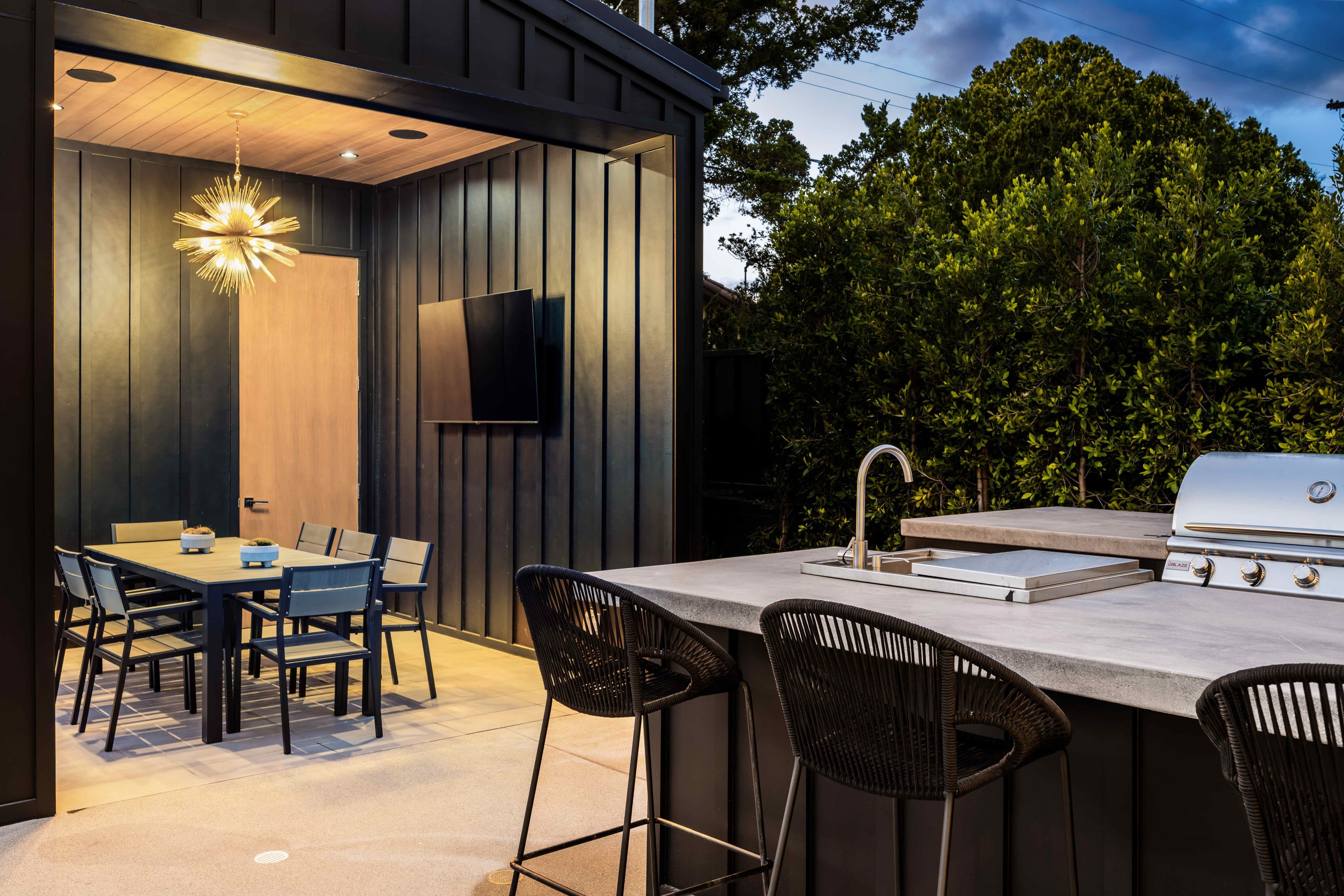 Modern covered patio pavilion with an outdoor kitchen and dining area
