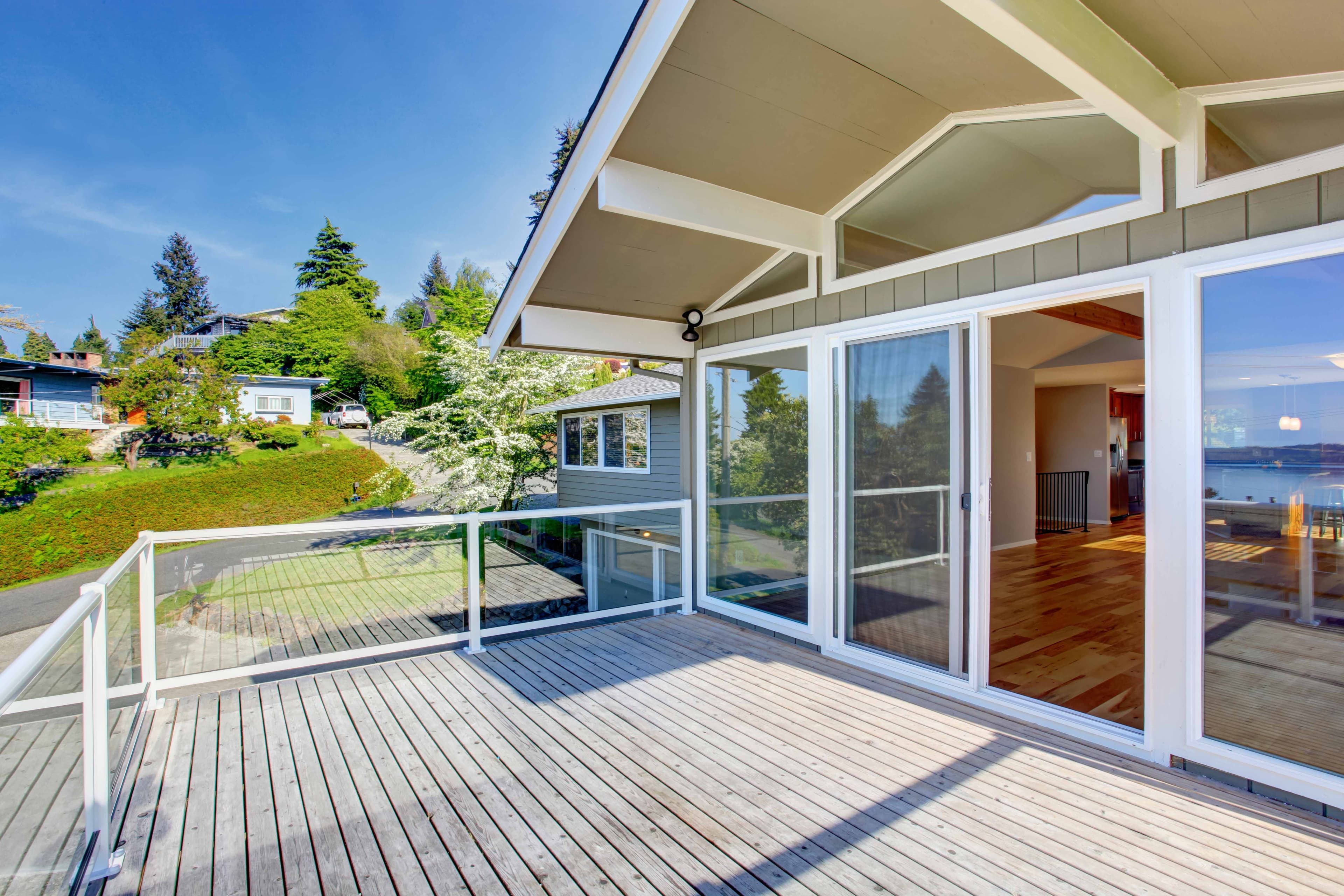 Exterior deck with a glass sliding door leading into a home interior