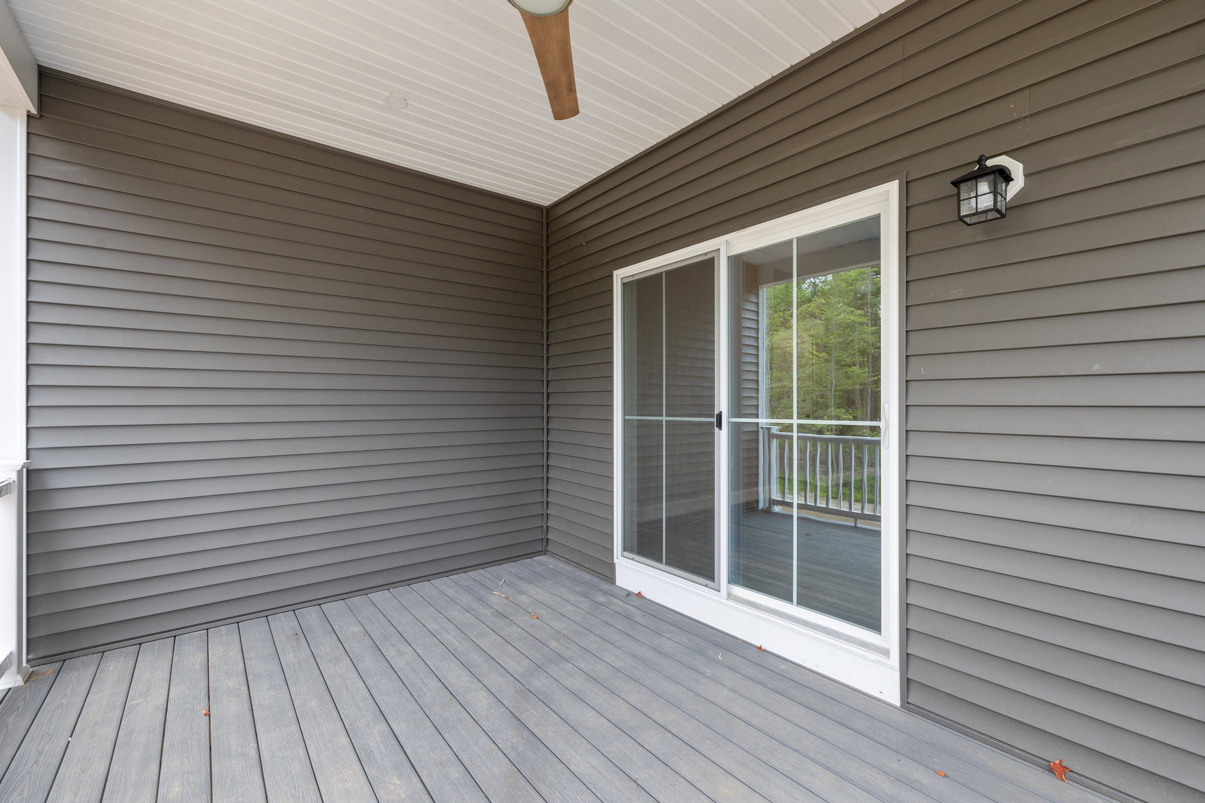 Sliding glass patio door with screen door leading to an exterior deck