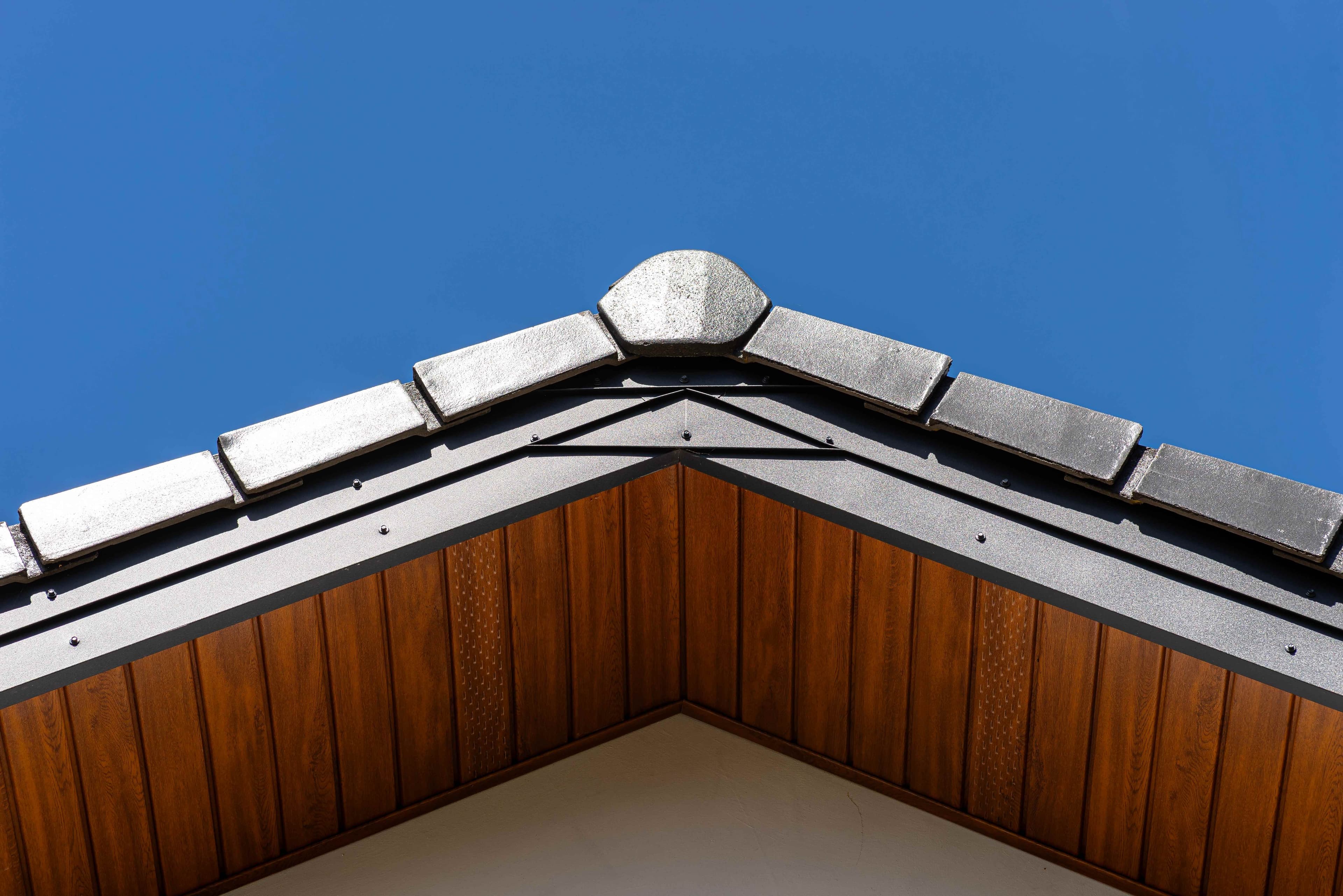 Wood-grain soffit panels and fascia trim at a gable peak