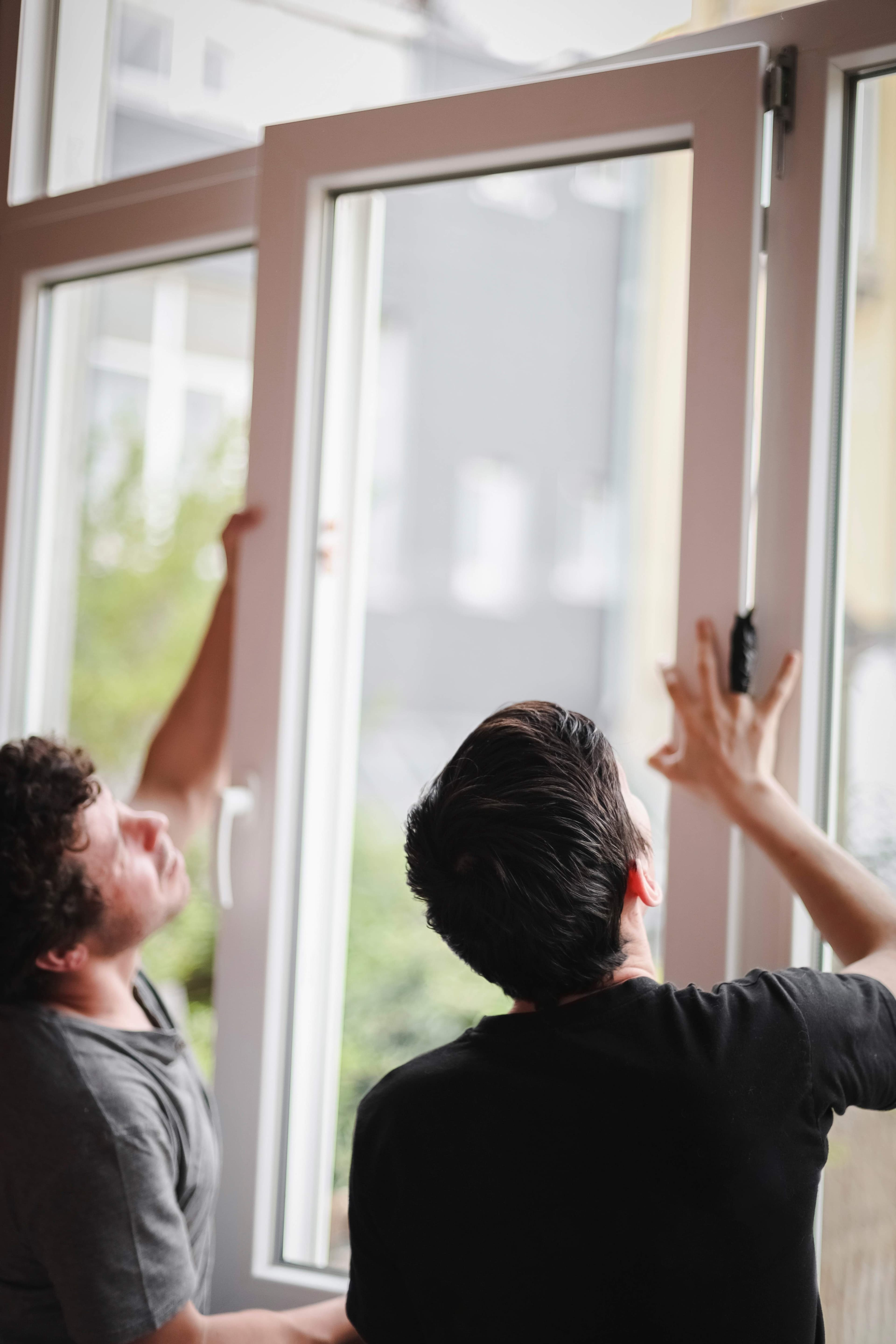 Technicians installing a casement window from indoors