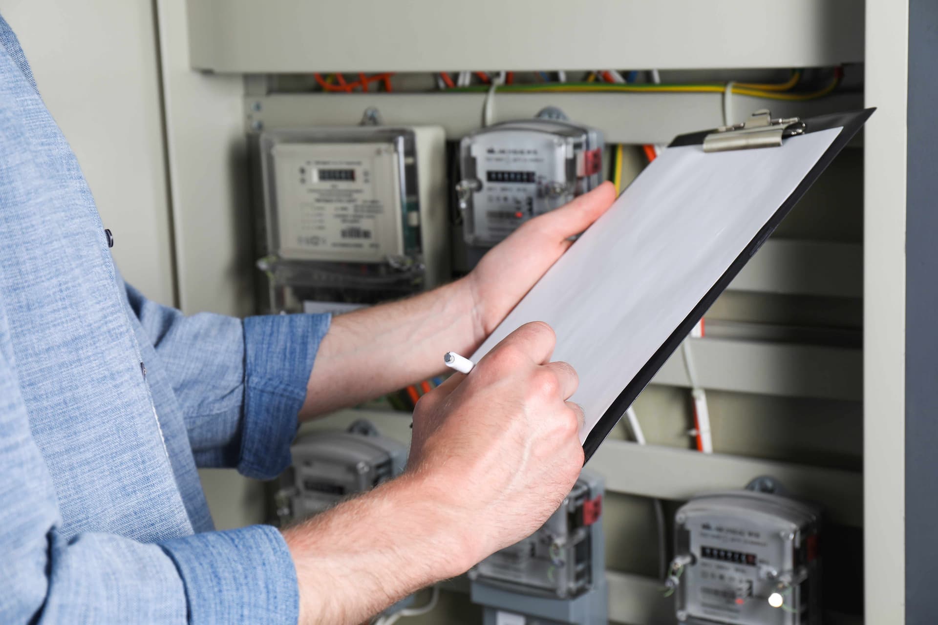 Technician holding inspection checklist in front of electrical panel