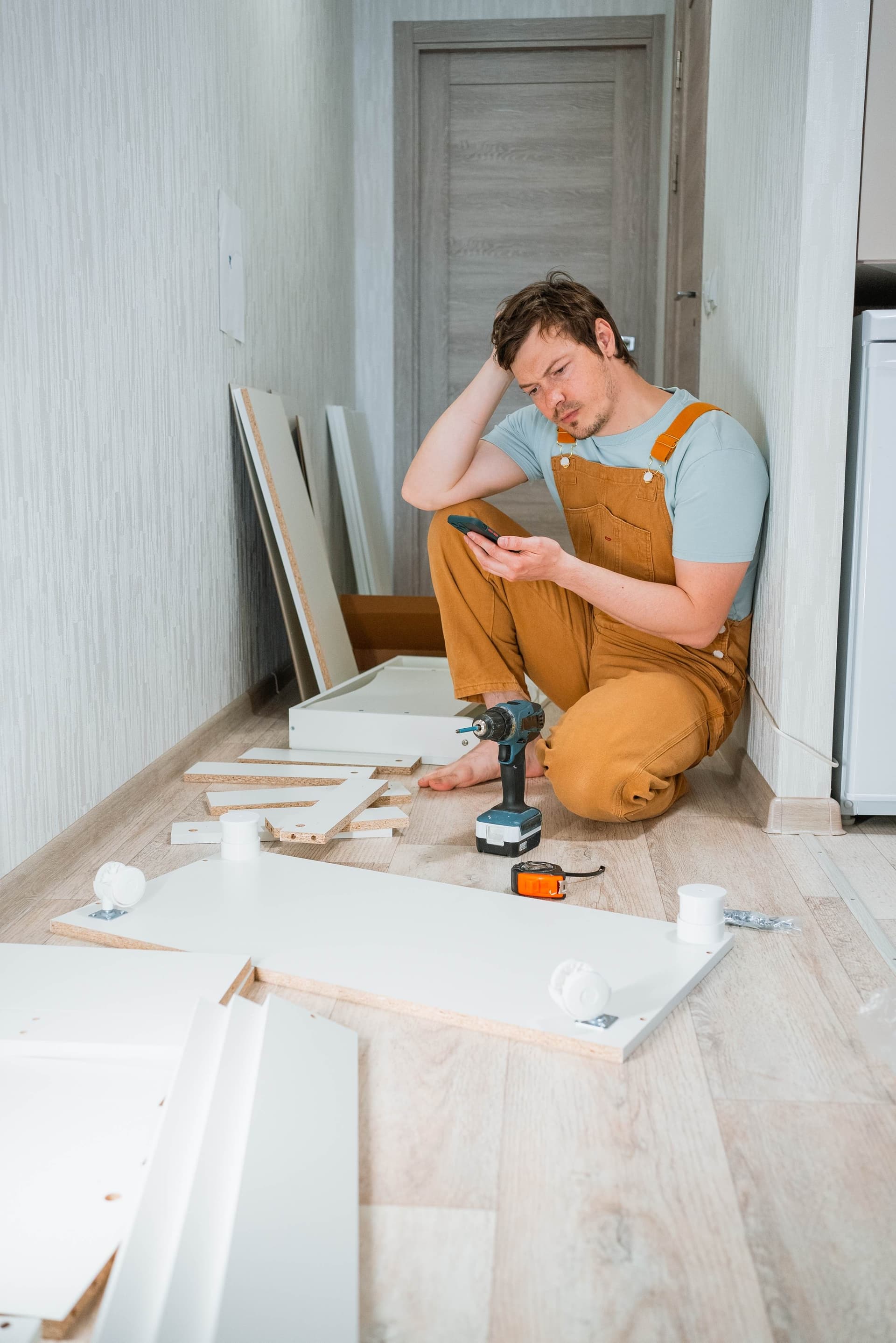Contractor examining paint chips on a wall in an interior renovation space